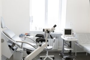Consultório de rotina de ginecologia com ultrassonografia, mesa ginecológica e colposcópio
