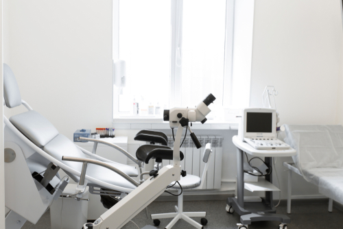 Consultório de rotina de ginecologia com ultrassonografia, mesa ginecológica e colposcópio